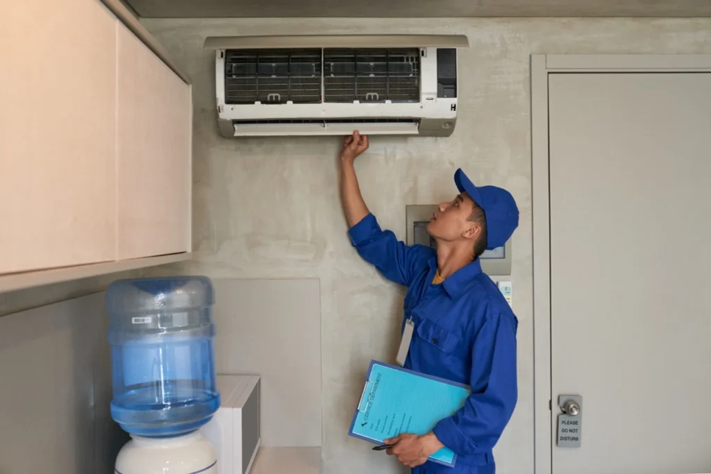 HVAC technician inspecting wall-mounted air conditioner unit in Seattle home